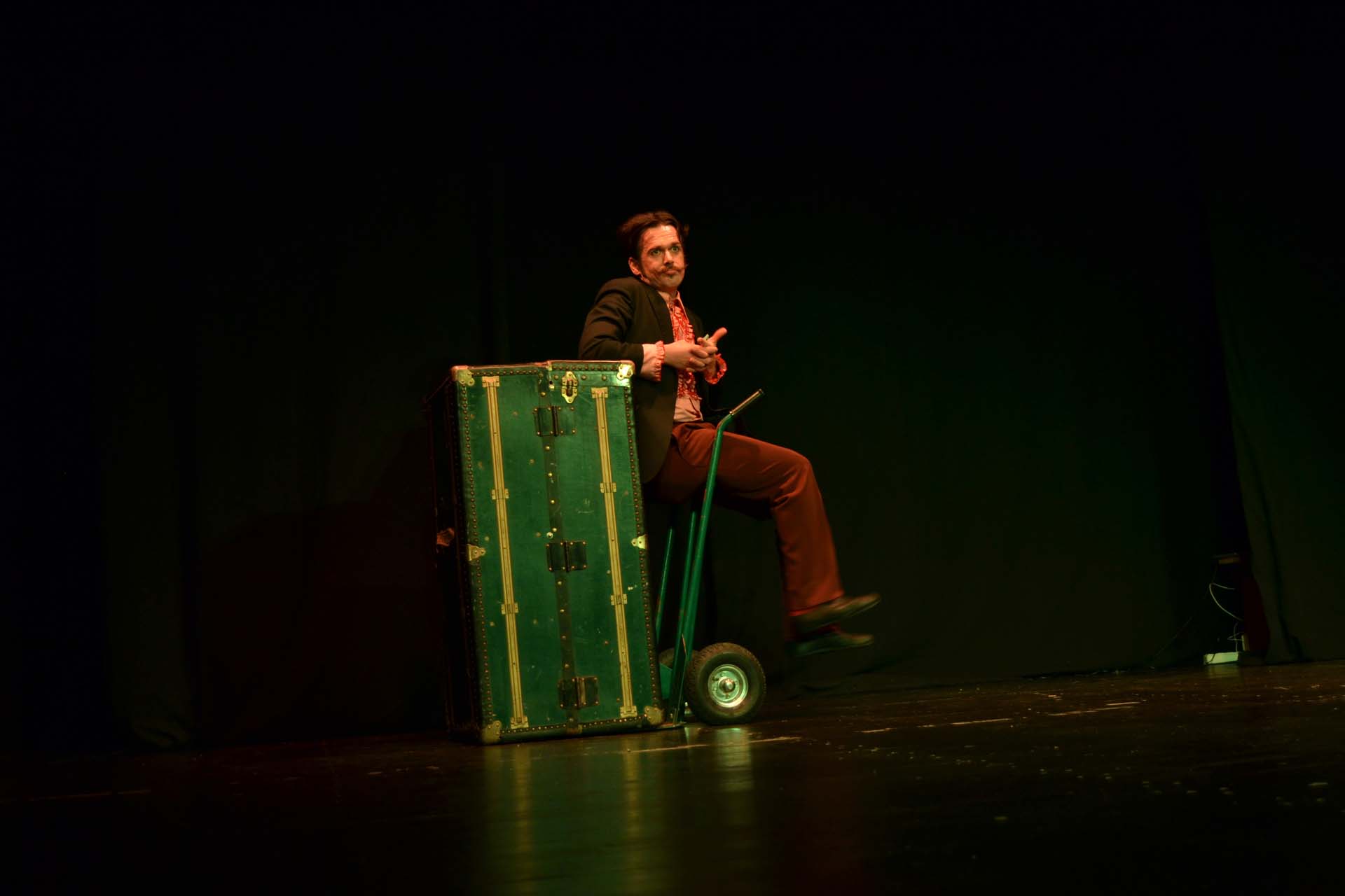 Un uomo su un palco con un baule