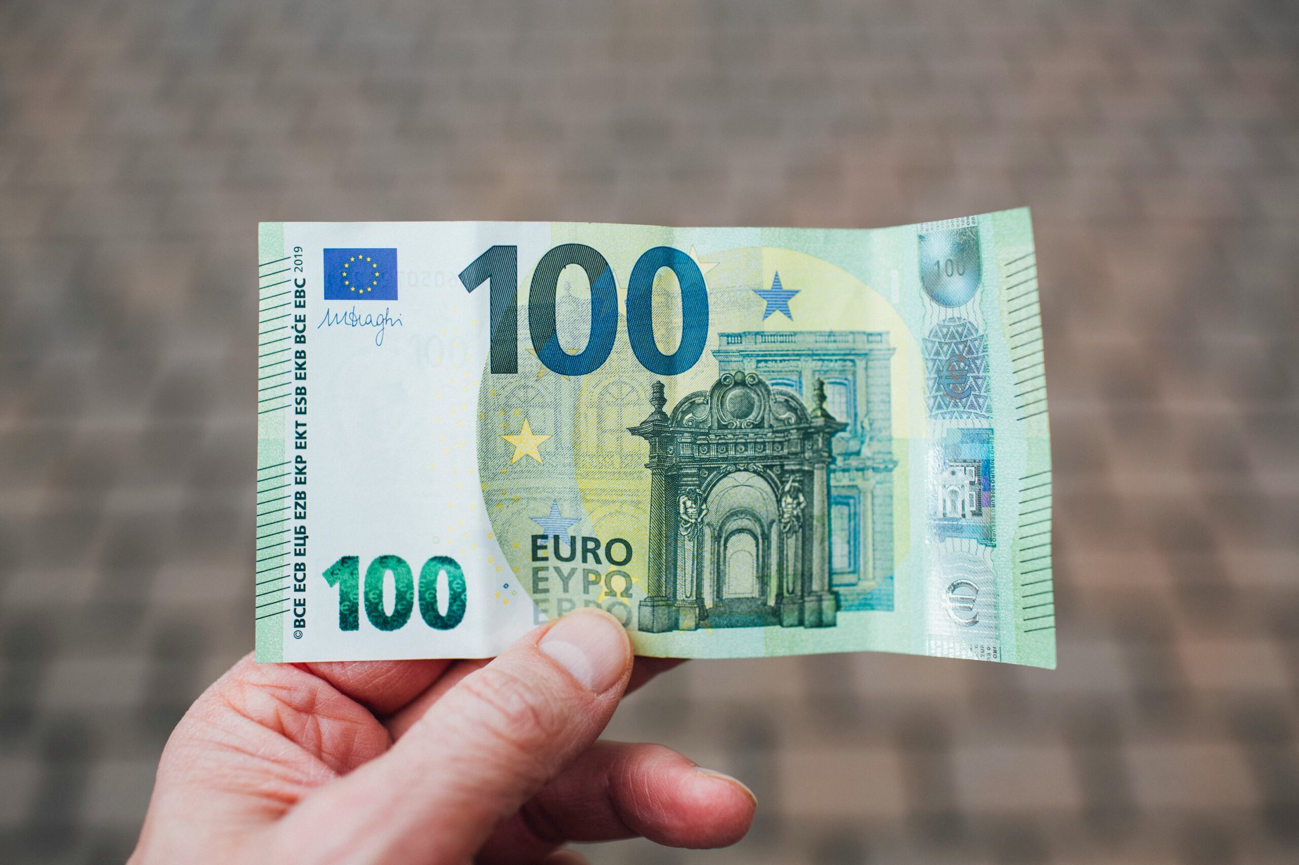 Foto di una mano che regge una banconota da cento euro